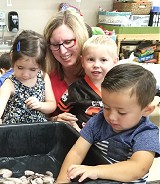 children with instructor studying ocean animal table at Vacaville Child Care